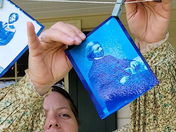 Christine pins up a wet cyanotype of Frederick Douglass.
